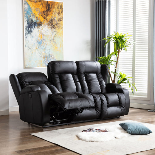 Black leather three-seater recliner sofa with one seat fully reclined, featuring cushioned backrests, cupholders, and vertical stitching, in a living room with wooden flooring and abstract wall art.
