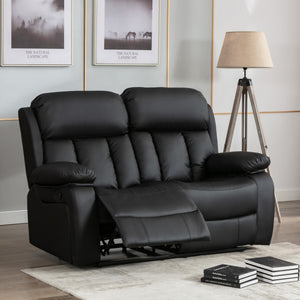 Black leather two-seater manual recliner sofa with padded armrests and vertically stitched backrests, with one seat reclined. The sofa is in a living room with a tripod floor lamp and landscape-themed wall art.