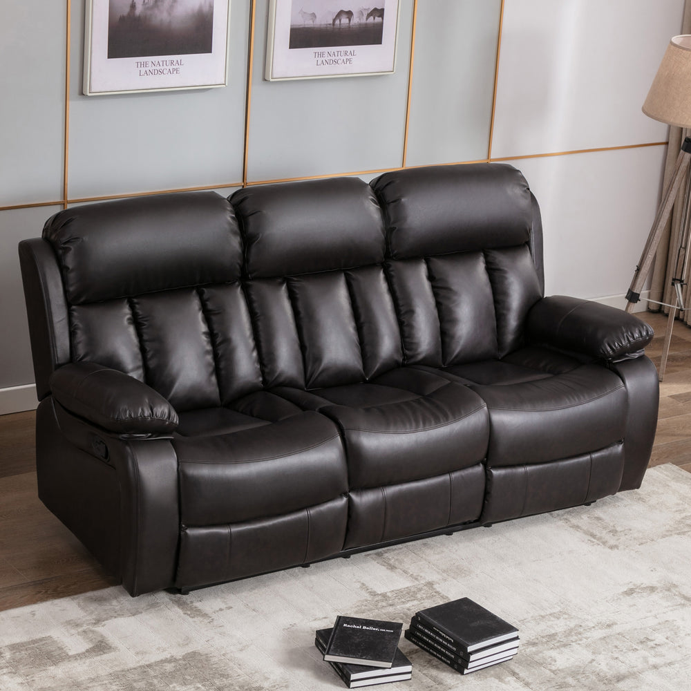 Dark brown leather three-seater recliner sofa with padded armrests and cushioned backrests featuring vertical stitching, placed on a light-coloured rug in a living room. Two photos hang above the sofa.