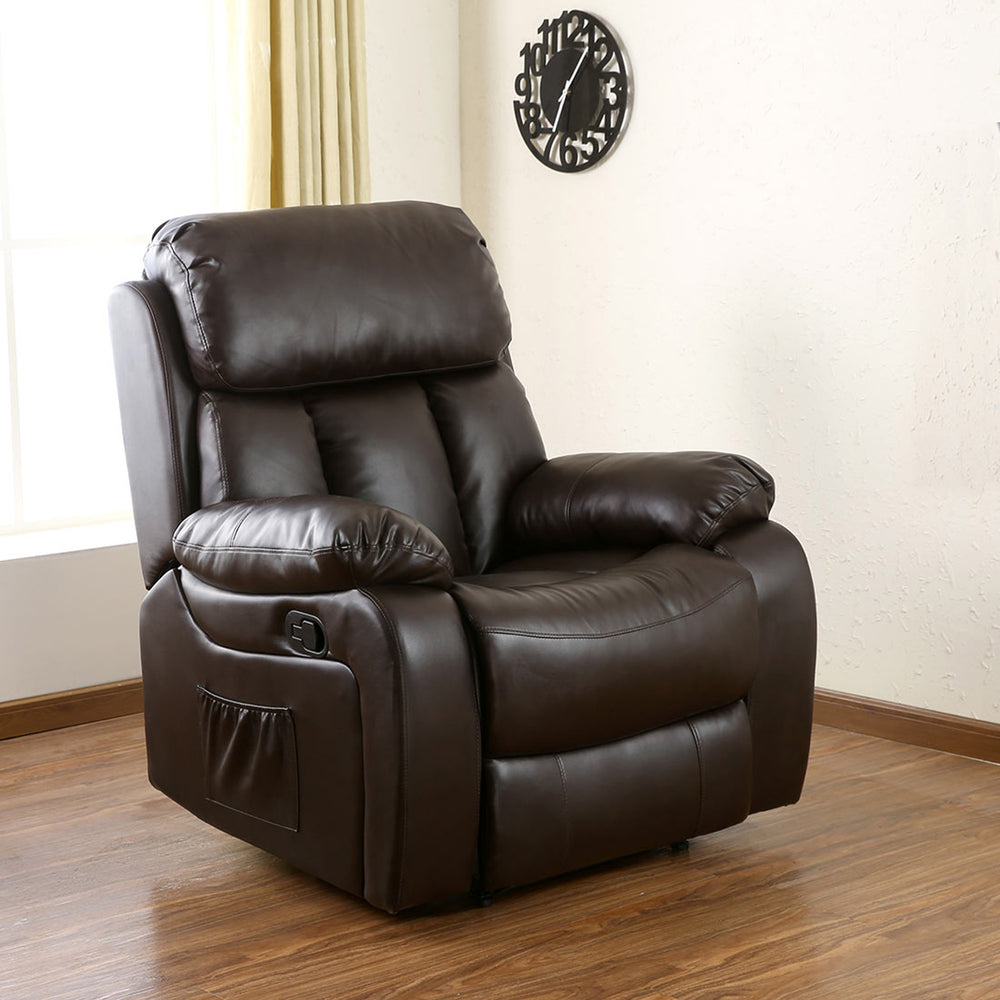 Dark brown leather manual recliner with padded armrests and a cushioned backrest featuring vertical stitching, positioned in a living room with wood flooring and a side pocket. The room is decorated with a clock.