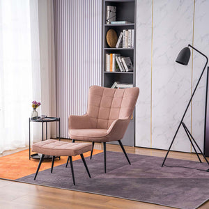 A pink linen accent chair with a matching footstool, both with black tapered legs, positioned in a room with a floor lamp, side table, and bookshelf.