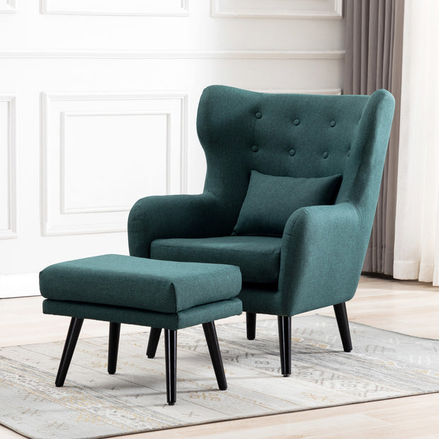 Green linen accent wingback chair with tufted buttons, paired with a matching footstool, set on a grey patterned rug against a white panelled wall.
