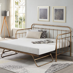 A white bedroom featuring a brass metal day bed with a trundle, white bedding, decorative pillows, and a plaid throw blanket. Two framed tree artworks hang above.