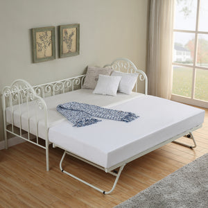  A white metal day bed with an extended trundle is adorned with white bedding, decorative pillows, and a blue throw blanket. Two botanical prints hang above the bed.