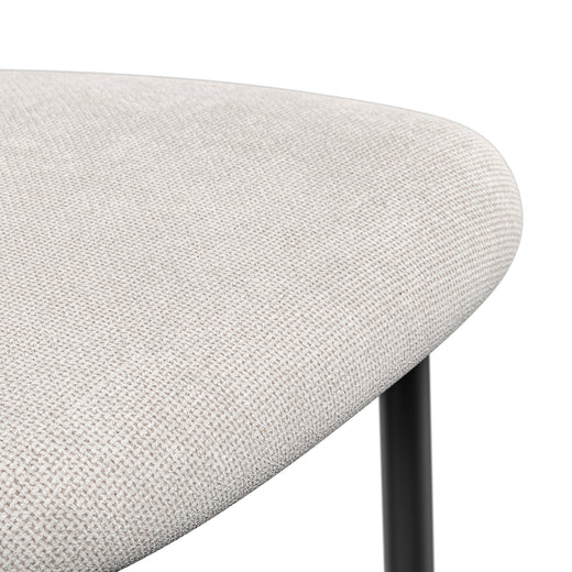 Close-up of a beige chair seat with a tightly woven texture and rounded edge