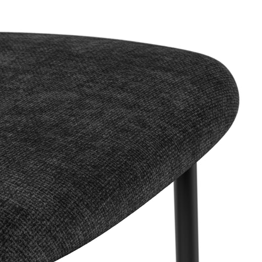 Close-up of a dark grey dining chair seat with a rounded edge and textured upholstery