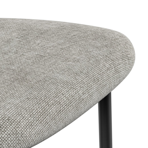Close-up of a grey dining chair seat with a tightly woven texture and rounded edge