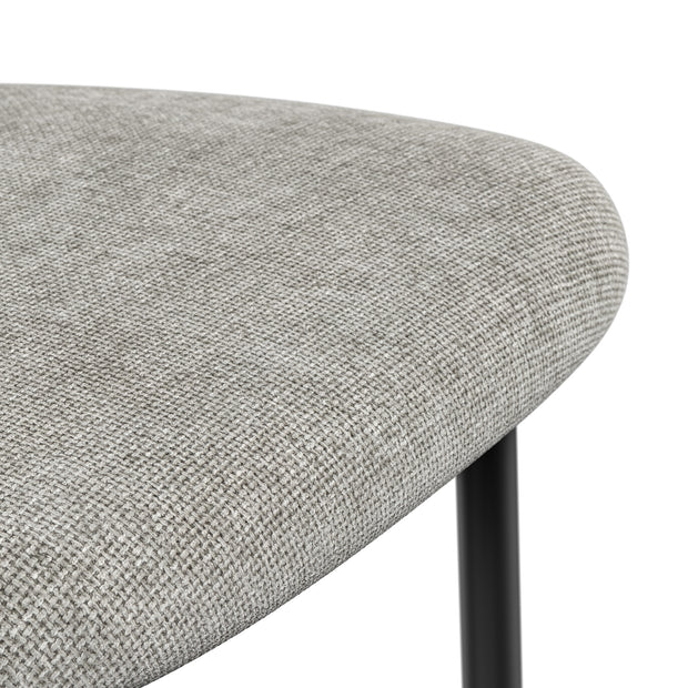 Close-up of a grey dining chair seat with a tightly woven texture and rounded edge