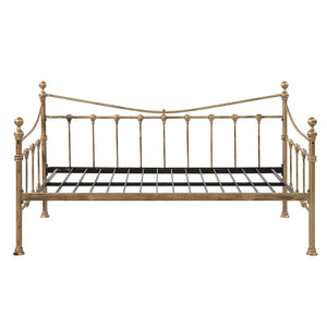 Brass-coloured metal day bed against a plain white backdrop.