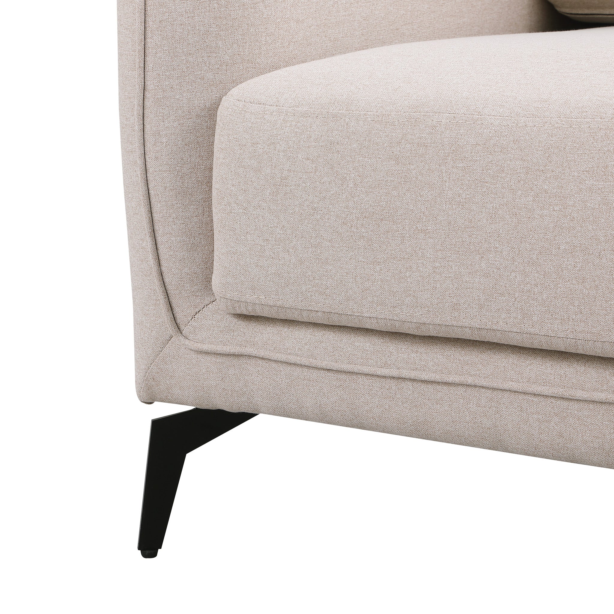 Close-up of a beige fabric sofa with black metal legs.