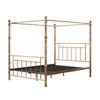 A brass-coloured metal four-poster bed with finials, decorative knobs, and vertical rods on the headboard and footboard, set against a plain white background.